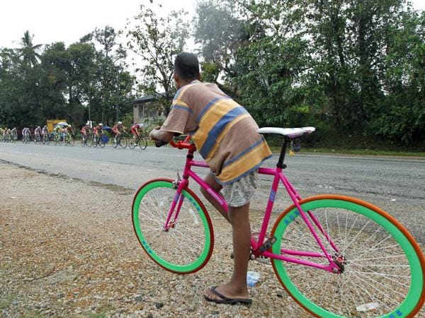 Während der 9. Etappe der "Tour de Langkawi 2012" in Malaysia wird das Fahrerfeld von einem einheimischen Rad-Fan beobachtet. Das Etappenrennen erhält seinen Namen von der Insel Langkawi in der Andamanensee.