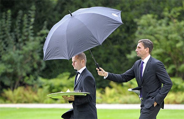 So sah es aus, als Wulff noch Bundespräsident war: Zwei seiner Mitarbeiter transportieren ein Tablett mit Schnittchen über den Rasen des Schlosses Bellevue