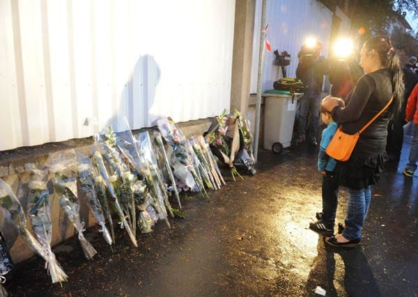 Mitschüler, Eltern und Freunde der Getöteten legen Blumen vor der Schule nieder.