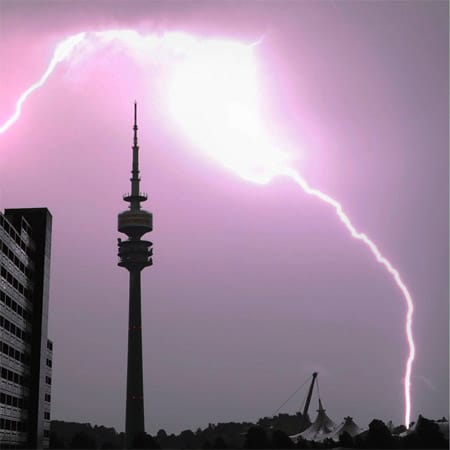 Olympiagelände in München: Ein Blitz entlädt sich. Mit Blitzen schießen zigtausende Ampere Starkstrom zur Erde - Elektrogeräte laufen mit rund zehn Ampere. In Bayern sind neben der Stadt München vor allem Landkreise südlich der Landeshauptstadt gefährdet.