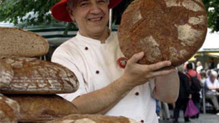 Bäcker hält Brot in der Hand
