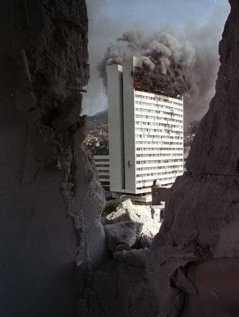 Artilleriegranaten der jugoslawischen Armee zerstören zahlreiche Gebäude, wie hier das Parlament im August 1992.