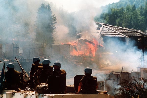 Diplomatische Bemühungen scheitern jedoch immer wieder, die UN-Blauhelme sind machtlos. UN-Soldaten beobachten am 14. August 1993, wie ein Hotel im Olympischen Dorf in Sarajevo in Flammen aufgeht.