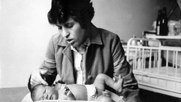 Maria W., Mutter des ersten deutschen Retortenbabys, streichelt in der Frauenklinik der Universität Erlangen kurz nach der Geburt ihren Sohn Oliver (Archivfoto vom 27.04.1982).