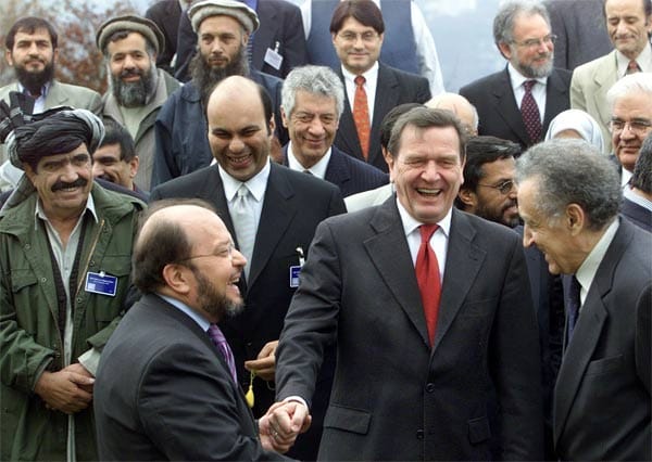 Unter UN-Schirmherrschaft treffen sich im Dezember 2001 Mudschahidin und afghanische Exilgruppen auf dem Petersberg bei Bonn, um die Grundlagen für das neue Afghanistan zu diskutieren. Sie einigen sich auf einen Stufenplan zur Demokratisierung des Landes sowie die Bildung einer provisorischen Regierung mit dem paschtunischen Stammesführer Hamid Karsai als Vorsitzenden.