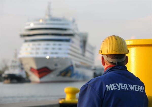 Ein letzter Blick auf das eigene Werk: Ein Werftarbeiter blickt auf die "AIDAmar", als den Werfthafen verlässt und ihre Überführungsfahrt auf der schmalen Ems in die Nordsee startet.