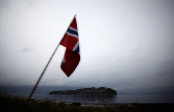 Blick auf die Insel des Verbrechens: eine norwegische Flagge hängt über einer Gedenkstätte.