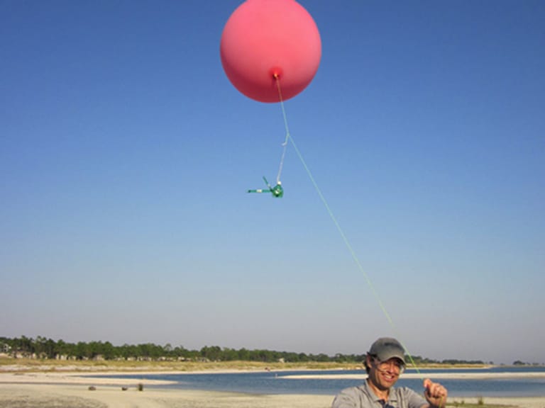 Unter dem mit Helium gefüllten Ballon hängt die Kamera, dieser steigt an einer Schnur kontrolliert in die Höhe.