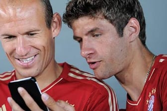 Arjen Robben und Thomas Müller (re.) werfen einen Blick aufs Handy.