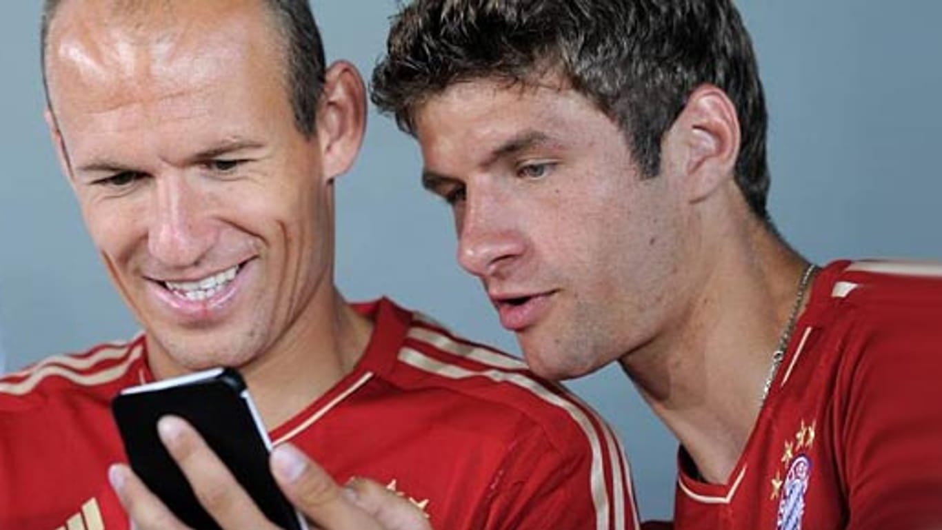 Arjen Robben und Thomas Müller (re.) werfen einen Blick aufs Handy.