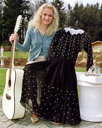 Nicole 20 Jahre später: In ihren Händen hält sie die Gitarre und das Kleid, mit dem sie zwei Dekaden zuvor den Grand-Prix gewann.