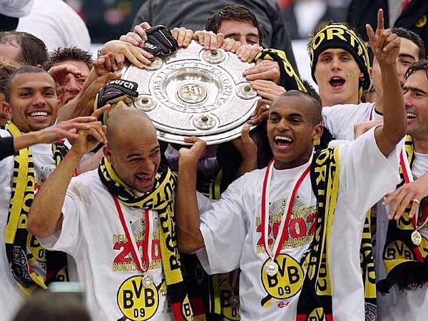 Im denkwürdigen Saisonfinish 2002 fängt der BVB den Konkurrenten Bayer Leverkusen auf der Zielgeraden noch ab. Es ist eine teuer erkaufte Meisterschaft der Dortmunder. Denn mit der Verpflichtung von kostspieligen Superstars wie Marcio Amoroso hat sich der Revierklub verhoben. Nur drei Jahre später steht der Klub vor der Insolvenz.