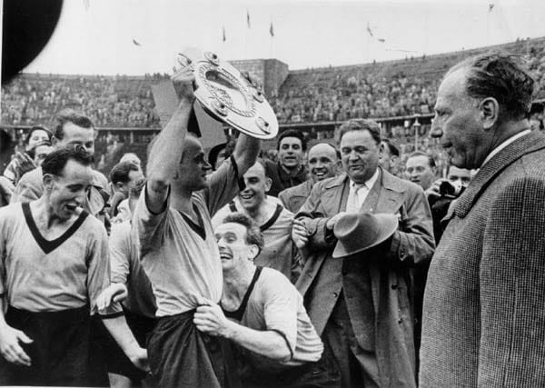 Den ersten Meistertitel feiern die Westfalen nach der Saison 1955/56. Adi Preißler präsentiert stolz die Schale. Vor 75.000 Fans im Berliner Olympiastadion hatte der Karlsruher SC mit 2:4 das Nachsehen.