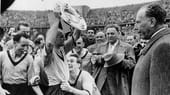 Den ersten Meistertitel feiern die Westfalen nach der Saison 1955/56. Adi Preißler präsentiert stolz die Schale. Vor 75.000 Fans im Berliner Olympiastadion hatte der Karlsruher SC mit 2:4 das Nachsehen.