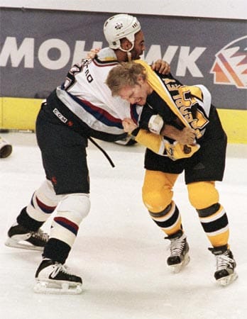 Simon ist aber nicht das größte Raubein der NHL: Marty McSorley (re.) schlägt am 21. Februar 2000 seinen Gegenspieler Donald Brashear (li.) mit dem Schläger gegen den Kopf. Brashear stürzt darauf rückwärts aufs Eis und bleibt bewusstlos liegen. McSorley wird daraufhin für den Rest der Saison gesperrt. Am 4. Oktober 2000 verurteilte ihn ein Gericht überdies zu einer Strafe von eineinhalb Jahren auf Bewährung. Die NHL weitete daraufhin die Sperre auf ein ganzes Jahr aus.