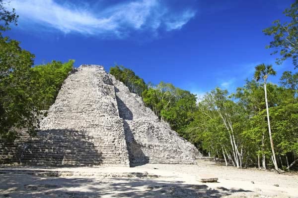 Cobá: 50000 Menschen sollen zu ihrer Blütezeit in Cobá gelebt haben. Kaum zu glauben, wenn man heute die ausgetretenen Stufen der Pyramide Nohochmul erklimmt. Von oben fällt der Blick nicht nur über das übliche tiefgrüne Meer aus Bäumen. Da und dort tauchen auch immer wieder Seen auf. Sie sind typisch für diese Metropole aus der Zeit der Maya-Klassik.