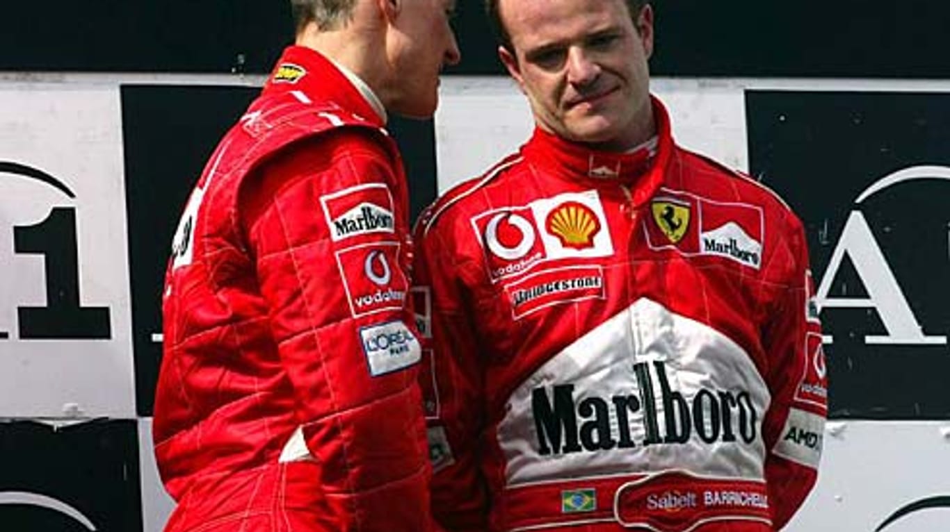 Szene vom Podium in Spielberg 2002: Michael Schumacher (li.) spricht mit dem sichtlich bedrückten Rubens Barrichello.