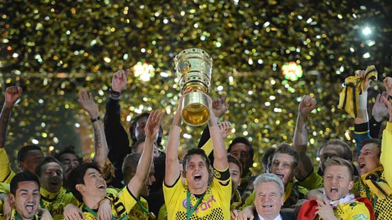 Da ist das Ding: BVB-Kapitän Sebastian Kehl stemmt den DFB-Pokal in die Höhe. Bundespräsident Joachim Gauck (Zweiter von rechts) hat ihn ihm gerade überreicht.