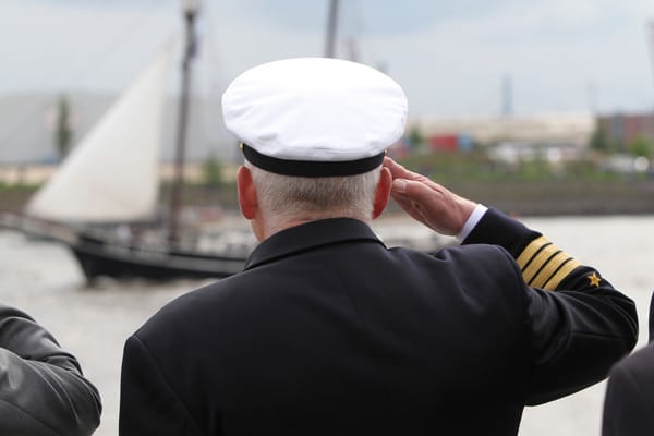 Ein Marine-Offizier begrüßt Schiffe der Einlaufparade des größten Hafenfestes der Welt.