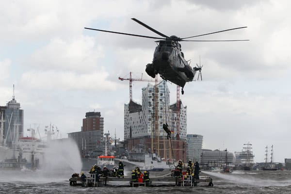 THW, Feuerwehr und ein Marine-Helikopter demonstrieren die Bekämpfung eines Brandfalls auf einem Schiff.