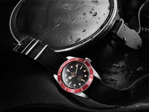 Sehr hübsch auch die bordeaux-farbene Lünette. Der Käufer dieser Uhr hat die Wahl zwischen einem schwarzen Textilarmband oder einem Armband aus gealtertem Leder. Tudor ist übrigens die kleine Schwester von Rolex. Die Marke wurde früher meist belächelt, weil sie keine Rolex-Werke in sich trug, sondern Standard-Werke.
