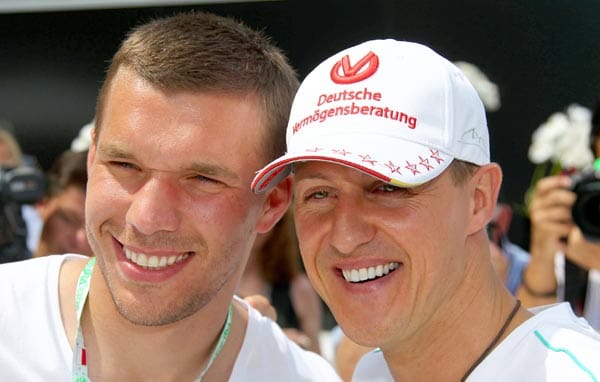 Das Kölner Idol Lukas Podolski strahlt mit Köln-Fan Michael Schumacher um die Wette.