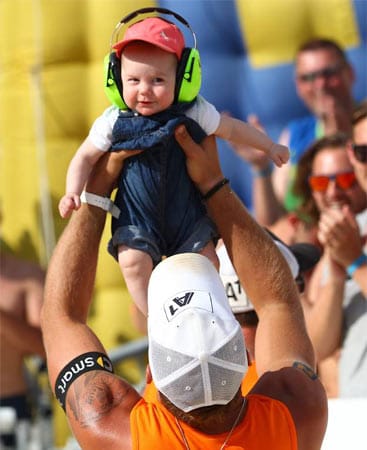 Der österreichische Beachvolleyballer Alexander Horst freut sich gemeinsam mit seiner kleinen Tochter Alessa. Sie trägt als Gehörschutz stylische Kopfhörer. Groß ist der Jubel über die beiden.