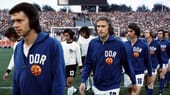 Obwohl die DFB-Elf 1974 die Weltmeisterschaft im eigenen Land gewinnt, blamiert sie sich gegen die Nachbarn aus der DDR. Es ist die Sternstunde von Jürgen Sparwasser (v.l.). Er schießt das entscheidende Tor zum 1:0 gegen die BRD im ersten Finalrunden-Spiel in Hamburg.