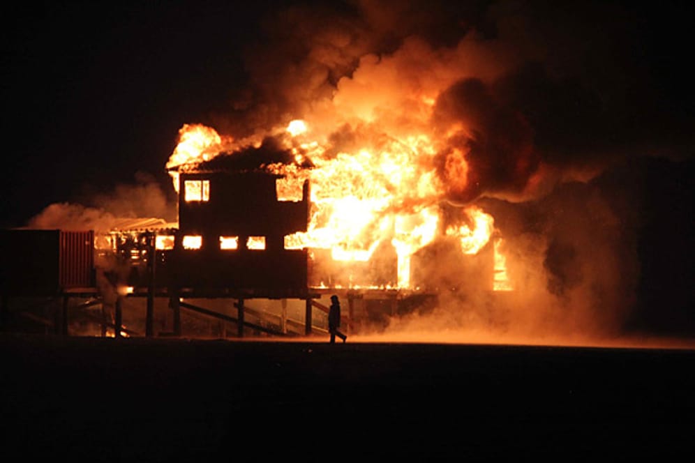 In voller Ausdehnung brennt am Morgen des 8. Juni 2012 ein Pfahlbau am Strand von St. Peter-Ording.