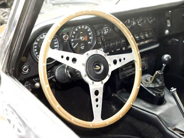 Das Armaturenbrett des Jaguar E-Type. Während die 3,8-Liter-Version noch einen Instrumententräger aus gedengeltem Blech besaß, hatte die nachfolgende 4,2-Liter-Version ab 1964 einen aus schwarzem Kunststoff.