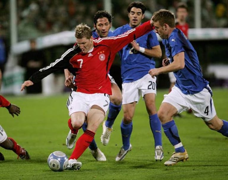 1. März 2006 in Florenz: Ins Jahr der Heim-WM startet die DFB-Elf mit einem Offenbarungseid. Das 1:4 in Florenz taucht Fußball-Deutschland in tiefes Dunkel. Nur drei Monate vor dem Eröffnungsspiel gegen Costa Rica erscheint die Elf von Ex-Nationaltrainer Jürgen Klinsmann nicht mehr konkurrenzfähig (hier attackieren Marco Materazzi, Simone Perrotta und Daniele de Rossi Bastian Schweinsteiger). Der aus den USA agierende Teamchef sieht sich schärfster Kritik ausgesetzt.