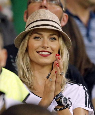 Lena Gercke trägt Hut. Die Farbe ihres Lippenstifts - Ton in Ton mit ihrem Nagellack.