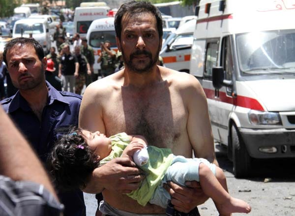 Ein Mann in Qudssaya trägt ein verwundetes Mädchen zu einem Krankenwagen. Sie habe "selten solche Brutalität gesehen", wie sie die syrische Armee Kindern antue, erklärt die UN-Beauftragte für Kinder in bewaffneten Konflikten, Radhika Coomaraswamy.