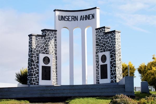 Auf einem Hügel erhebt sich ein Denkmal mit den Worten "Unsern Ahnen", das den ersten Siedler aus der Mitte des 19. Jahrhunderts gewidmet ist.