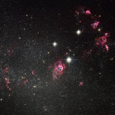 Die Zwerggalaxie Holmberg II wird dominiert von riesigen Blasen mit glühendem Gas - dort werden Sterne gebildet.