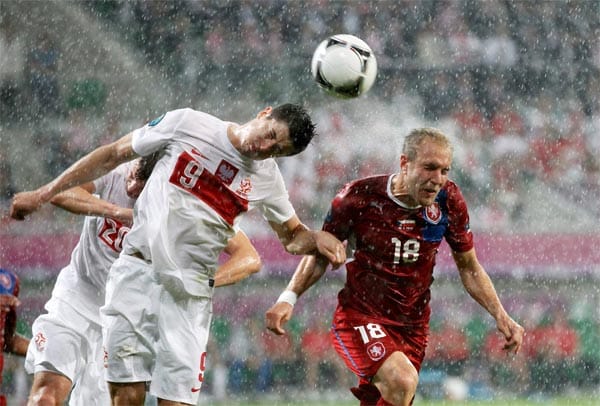 Der Regen wird stärker. Der Partie tut dies aber keinen Abbruch. Beide Mannschaften spielen auf Sieg. Robert Lewandowski (li.) köpft den Ball vor Tschechiens Daniel Kolar.