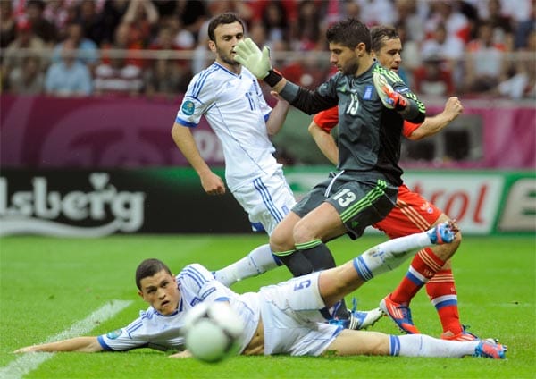 Die größeren Chancen haben zunächst aber die Russen. Hier kann der Schalker Kyriakos Papadopoulos (liegend) im letzten Augenblick den Ball am Tor vorbei lenken. Der russische Stürmer Aleksandr Kerzhakow hat die Chance vergeben. Griechenlands Torwart Michalis Sifakis pustet durch, während Vassilis Torossidis die Augen zuschlägt.