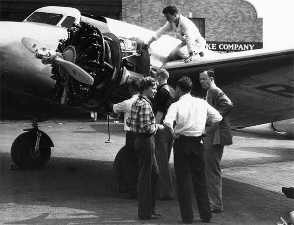 Earhart 1936 im Gespräch mit Freunden und ihrem Ehemann George Palmer Putnam (rechts) auf dem Floyd-Bennett-Flugplatz in Brooklyn, New York. Kurz darauf flog sie nach Los Angeles, um an einem Rennen teilzunehmen. In eine Ehe hatte sie nur widerstrebend eingewilligt - aus Angst, in ihrer Fliegerei eingeschränkt zu werden.