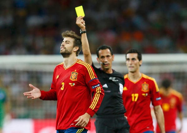 Spaniens Gerard Piqué sieht für seinen zu harten Einsatz gegen Antonio Cassano Gelb.