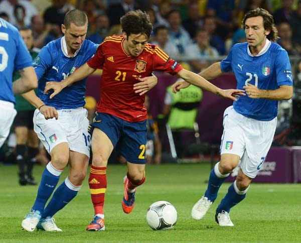 Spanien erwischt den besseren Start. Die Italiener Andrea Pirlo (re.) und Leonardo Bonucci (li.) nehmen David Silva in die Zange.