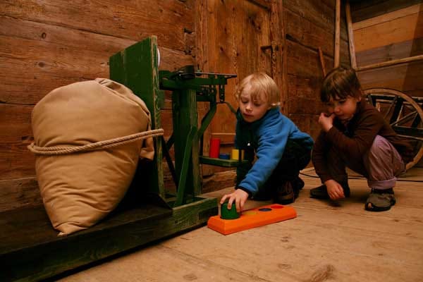 Kinder gehen im Mirznhaus auf Entdeckungsreise und probieren aus, wie auf dem Waschbrett gewaschen oder auf einem Holzofen gekocht wurde.