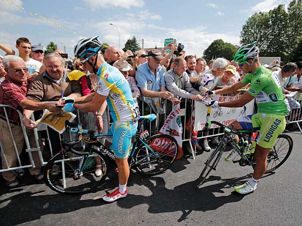 Zur Unterschrift bitte: Vor dem Etappenstart holen sich die Tour-Fans immer wieder Autogramme der Rennfahrer. Hier geben Alexandre Winokurow (links) und Peter Sagan ihr Bestes.