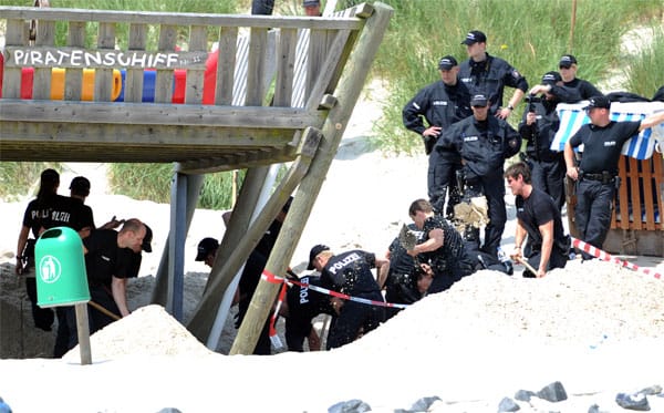 Die Polizei gräbt den Strand unter dem "Piratenschiff"-Klettergerüst auf und findet die Leiche des Kindes unter anderthalb Metern Sand. Die Polizei gräbt den Strand unter dem "Piratenschiff"-Klettergerüst auf und findet die Leiche des Kindes unter anderthalb Metern Sand.