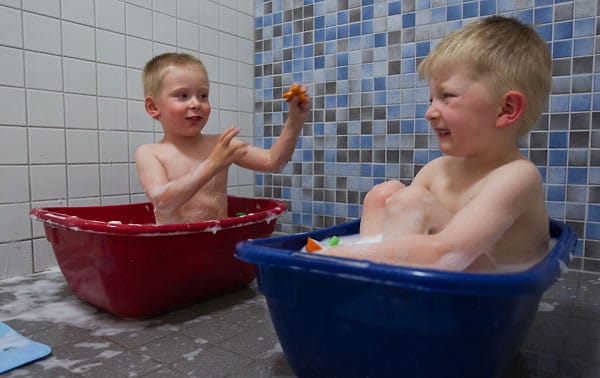Yannic (r) und Dean (l) baden vor dem Schlafen in bunten Plastikbadewannen. Für viele Eltern reichen die normalen Betreuungszeiten von 8:00 bis 16:00 nicht mehr aus.