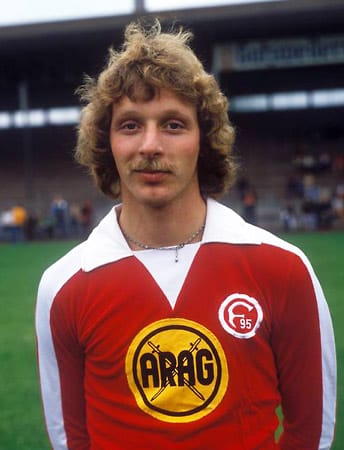 Kette, Locken, Schnauzer. Rüdiger Wenzel hat 1979 alles, was ein Fußballer braucht. Der gebürtige Lübecker bringt es 1975 bis 1990 auf beachtliche 300 Bundesliga-Einsätze und 91 Tore.