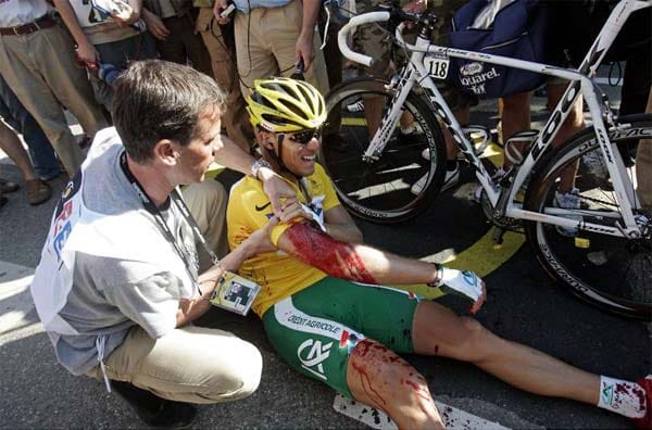 2. Juli 2006: Im Ziel der 1. Etappe in Straßburg bricht der Norweger Thor Hushovd zusammen, Blut aus einer klaffenden Wunde am rechten Oberarm färbt sein Gelbes Trikot dunkelrot. Hushovd hatte im Zielsprint eine grüne Papp-Winkehand gestreift. Wie ein Messer schlitzt das Souvenir den Arm auf.