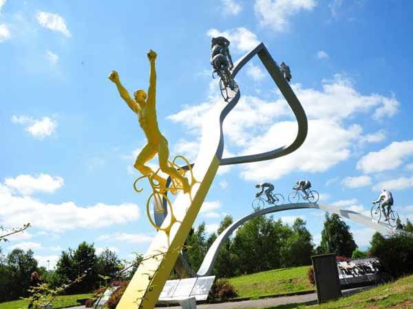 "The Winner takes it all": Moderne Kunst, die die ganze Faszination des Radsports veranschaulicht. Während vorne der Mann in Gelb bereits jubelnd die Arme nach oben reißt, mühen sich die Verfolger noch strampelnd ab.