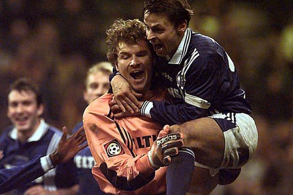Schalke-Torwart Jens Lehmann lässt sich nach seinem Kopfballtreffer gegen Rivale Dortmund von seinem Mitspieler Olaf Thon feiern.