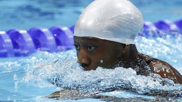 Dede Camara hat bei ihrem Auftritt über 100 Meter Brust sichtlich mit sich und dem Wasser zu kämpfen. Die Schwimmerin aus Guinea kommt aber doch noch an, wenn auch über eine halbe Minute nach der schnellsten Konkurrentin: 1:38 Minuten braucht sie für die Strecke.