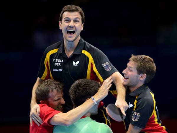 Timo Boll (oben), Dimitrij Ovtcharov (in Grün) und Bastian Steger sichern sich die Bronze-Medaille im Mannschafts-Wettbewerb.